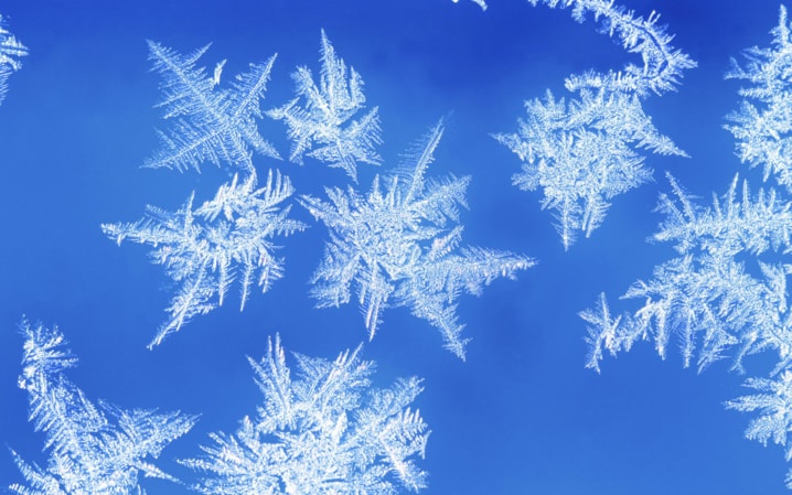 Snowflakes on glass, close-up, blue background