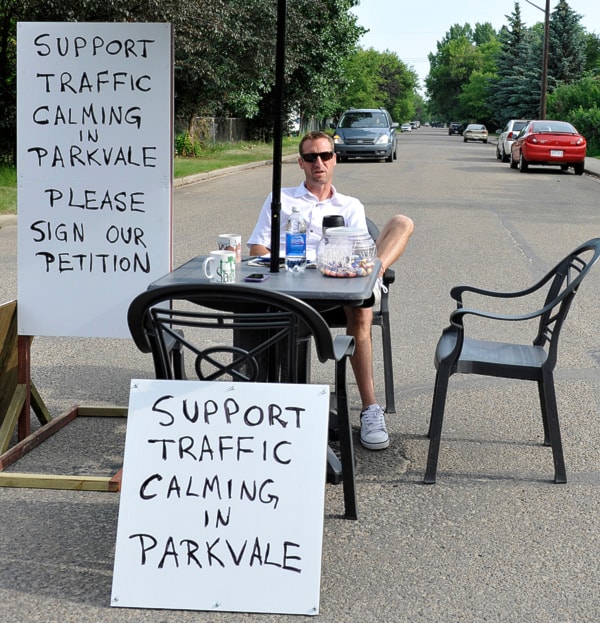 Brandon Bouchard sits at the intersection of 46 Ave and 45 St in Red Deer waiting for passerbys and traffic. The patio table was set up by Brandon Bouchard who is gathering na