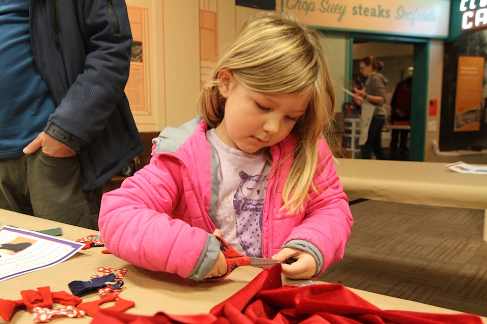 Eva Wilson cuts some fabric to put together a patchwork poppy at the Red Deer Museum and Art Gallery on Remembrance Day. (Photo by Sean McIntosh/Advocate staff)