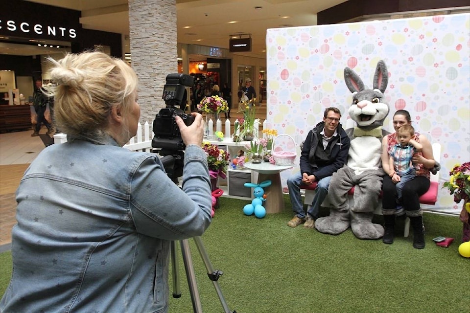 Brandon Wegner, Ashly Dixon and their two-year-old son Kratos take their picture with the Easter bunny at Bower Place Friday in Red Deer. (Photo by SEAN MCINTOSH/Advocate staff)