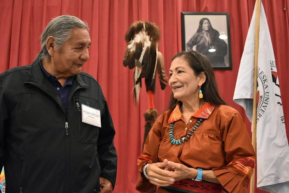 FILE -Russell Eagle Bear, with the Rosebud Sioux Reservation Tribal Council, talks to U.S. Interior Secretary Deb Haaland during a meeting about Native American boarding schools at Sinte Gleska University in Mission, S.D., Saturday, Oct. 15, 2022. Haaland plans to be in Bozeman, Mont. Sunday to wrap up her nationwide tour confronting the legacy of the institutions where students were often abused. (AP Photo/Matthew Brown, File)