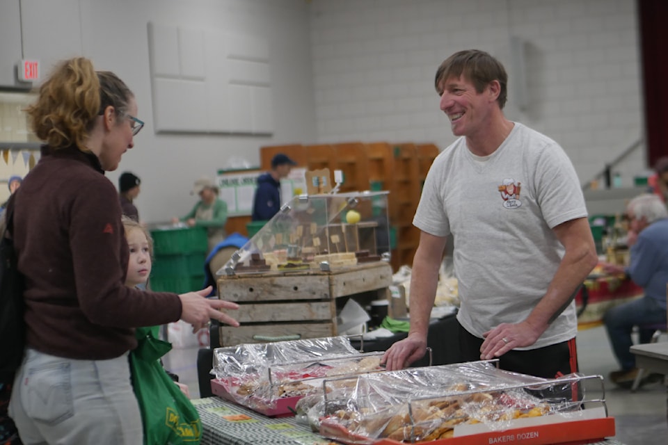 Baker Fritz Priwall shares a laugh with customers at the Revelstoke Local Food Initiative's winter farmers' market on Saturday, Jan. 11, after managing to finish his baking the day before despite a power outage in his home of Sicamous.
