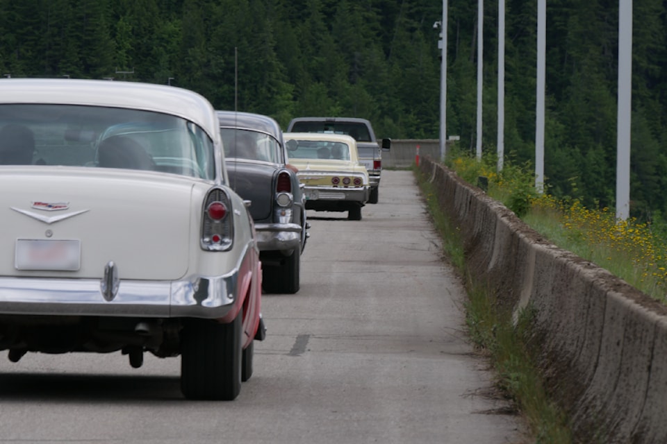 Vintage cars cruise over the Revelstoke Dam on Friday, June 6, ahead of the Revelstoke Mountain Paradise Show & Shine.