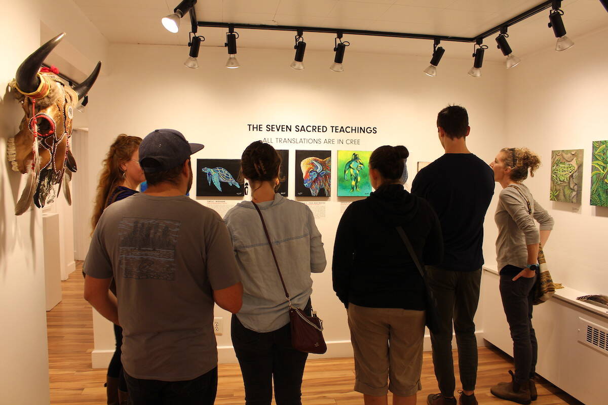 A group examining one of Delree Dumonts (Wâpiski Kihéw Esquao) pieces. (Zachary Delaney)