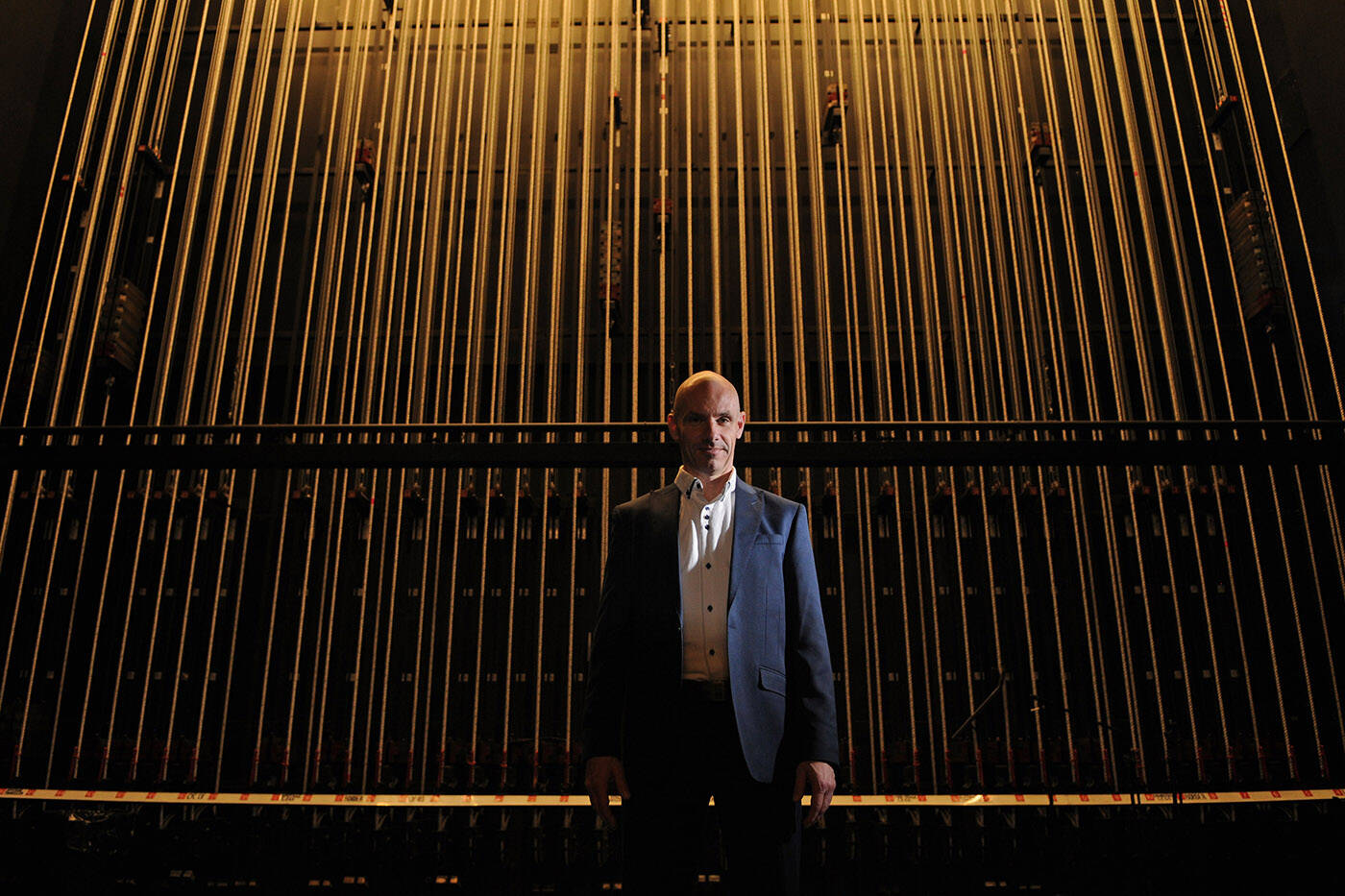 Newly hired executive director of the Chilliwack Cultural Centre, Jean-Louis Bleau, is seen backstage in front of dozens of ropes and pulleys at the Hub International Theatre inside the centre on Tuesday, Oct. 25, 2022. (Jenna Hauck/ Chilliwack Progress)