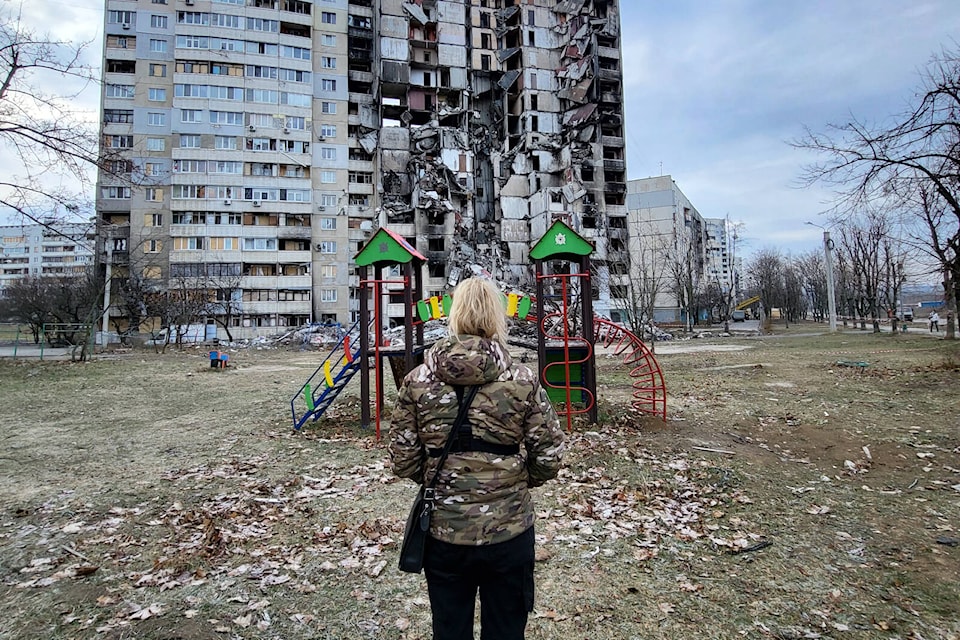 April Huggett stands in front of a destroyed apartment building in the Saltovka area of Kharkiv. Photo: Submitted