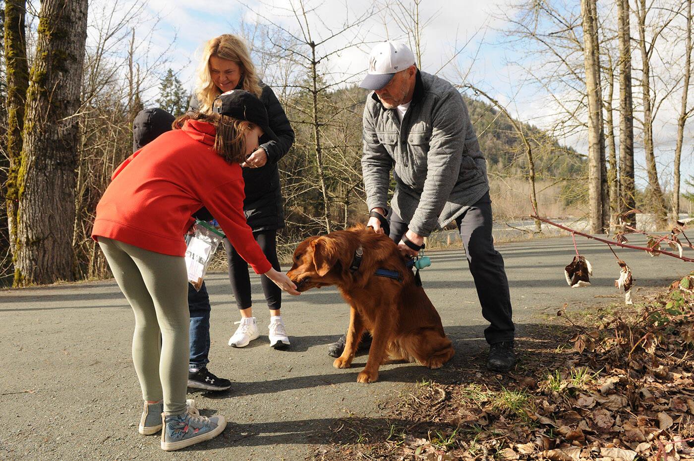 Jade Pennock gives a dog a treat near Vedder Park during Watson Elementarys Kindness Project on Wednesday, March 15, 2023. (Jenna Hauck/ Chilliwack Progress)