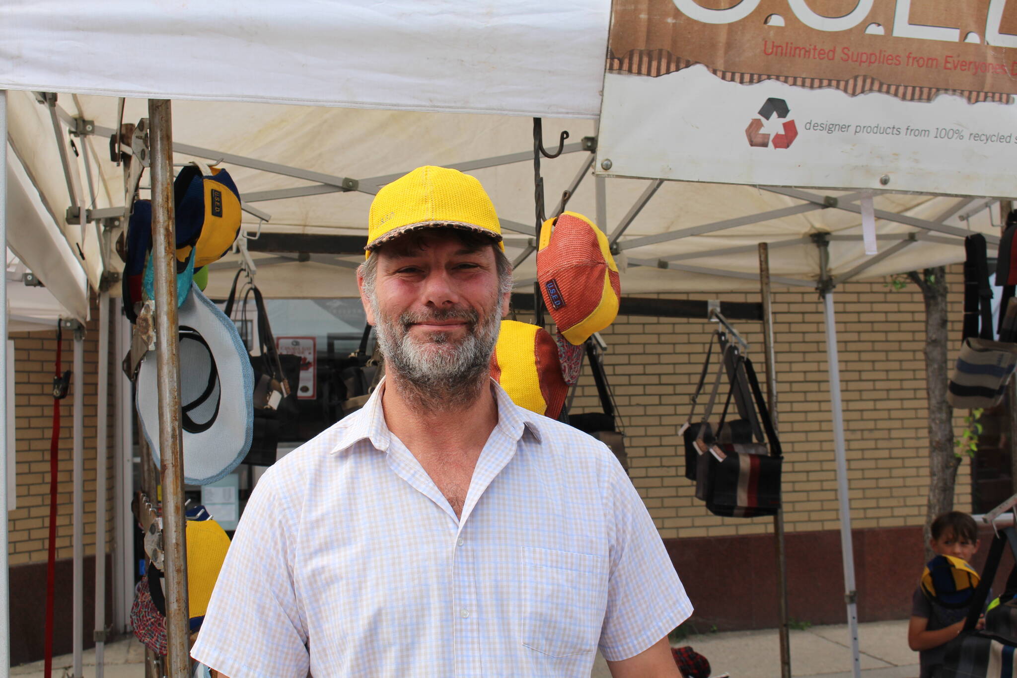 Trevor Kehler stands in front of his U.S.E.D. stand sporting one of his own hats at the LFI Farmers Market in Revelstoke, June 17, 2023. (Zachary Delaney/Revelstoke Review)