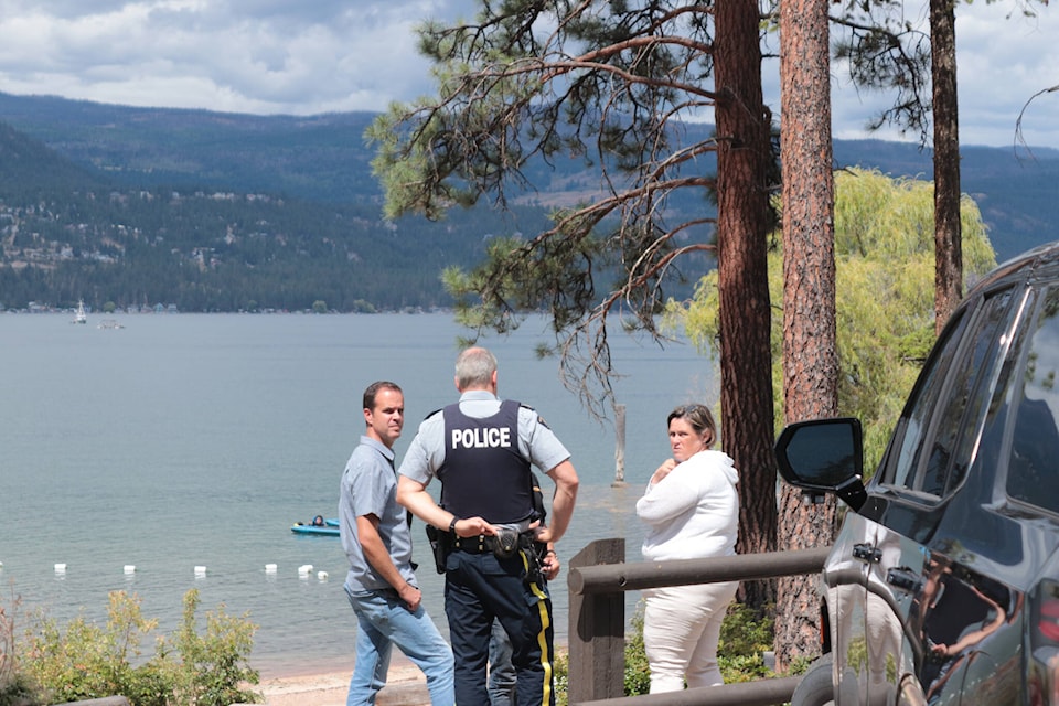 RCMP officers were at Hurlburt Park on Wednesday, July 26, two days after a fishing boat capsized on Okanagan Lake and the man driving the boat did not surface. (Brendan Shykora/Morning Star)