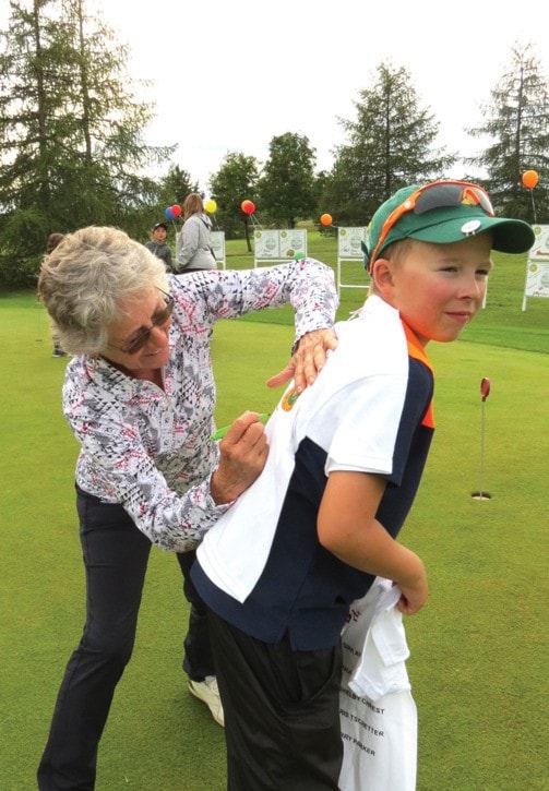 Golf pro Sandra Palmer signs a T shirt for nine-year-old Easton McKinlay.