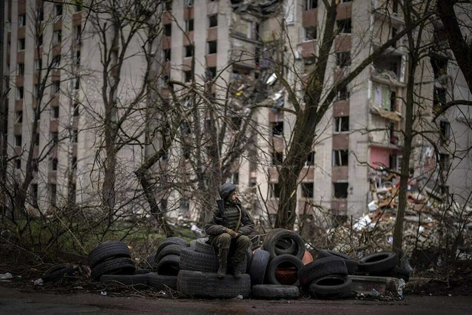 A Ukrainian soldier sits on tyres next to a building destroyed by Russian bombing in Chernihiv on Saturday, April 23, 2022. (AP Photo/Emilio Morenatti)