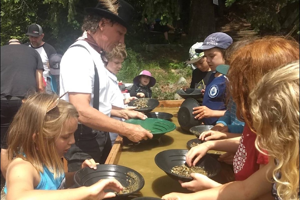 Local history buff and geologist Dan Wherle teaches youngsters the fun of panning for gold.