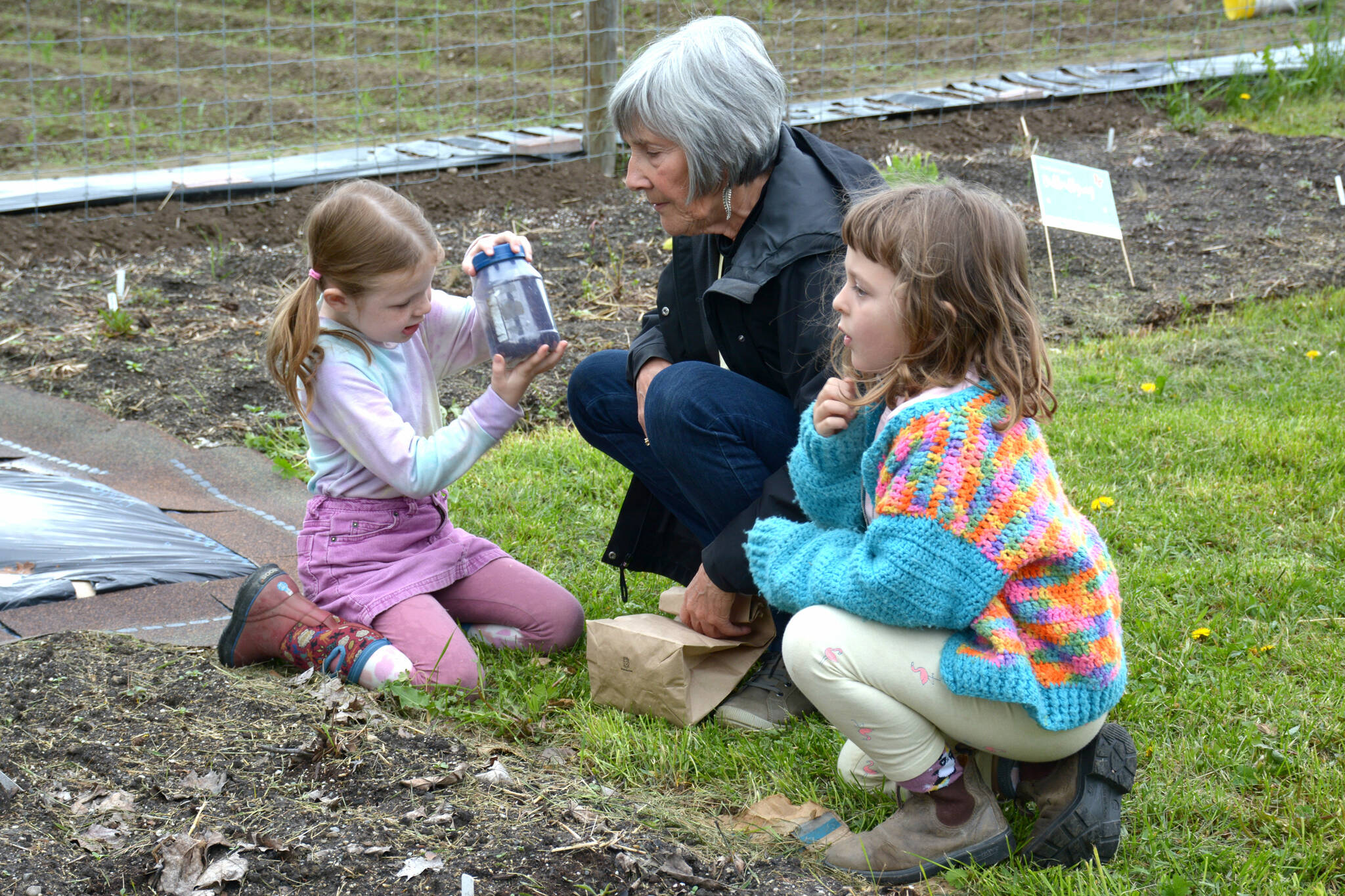 Caroline Collier shows two students how to plant Douglas aster seeds. (Photo by Kelsey Yates)