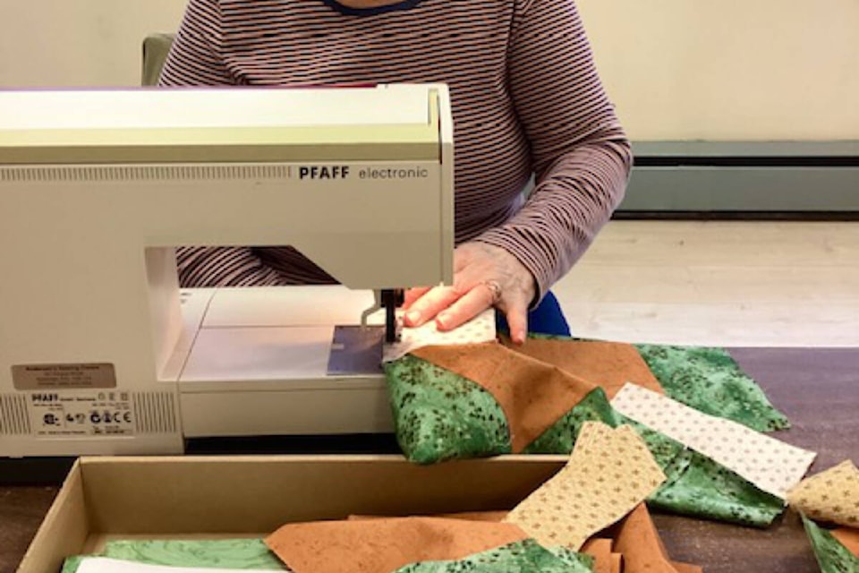 Alice Witt, a Tuesday Morning Quilter, readies a piece for the upcoming show and sale on Saturday, Nov. 5 in the Trail United Church hall. Photo: Sheri Regnier
