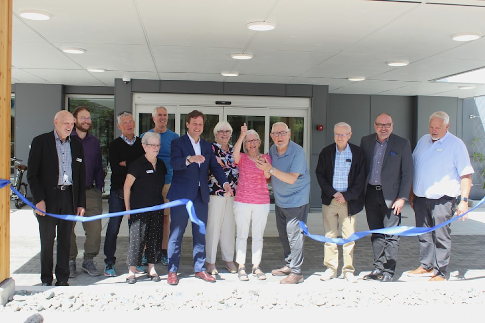 Linwood Court resident Anke Anderson cuts the ribbon to celebrate the grand opening of the new 97-unit seniors home. 
