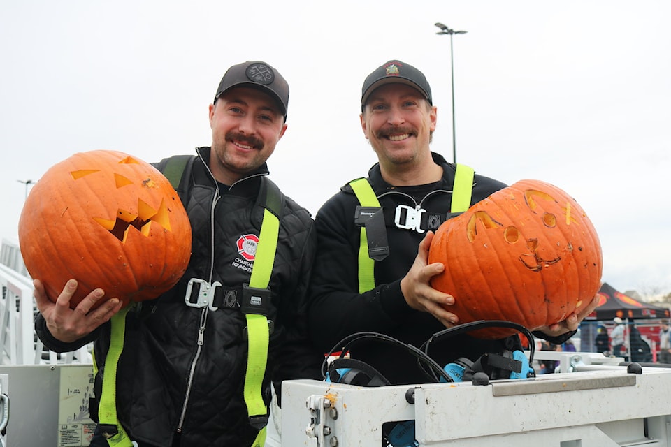 Saanich firefighters Zach Cunningham and Nick Short, load up for another pumpkin drop.