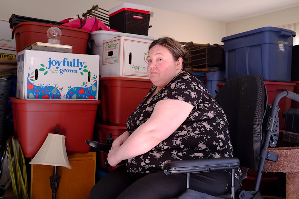Fran Hayes, a single mom of two teenagers, sits in her wheelchair, surrounded by packed boxes containing all her belongings and those of her two children. The family is preparing to leave after receiving an eviction notice from the Capital Region Housing Corporation in March.