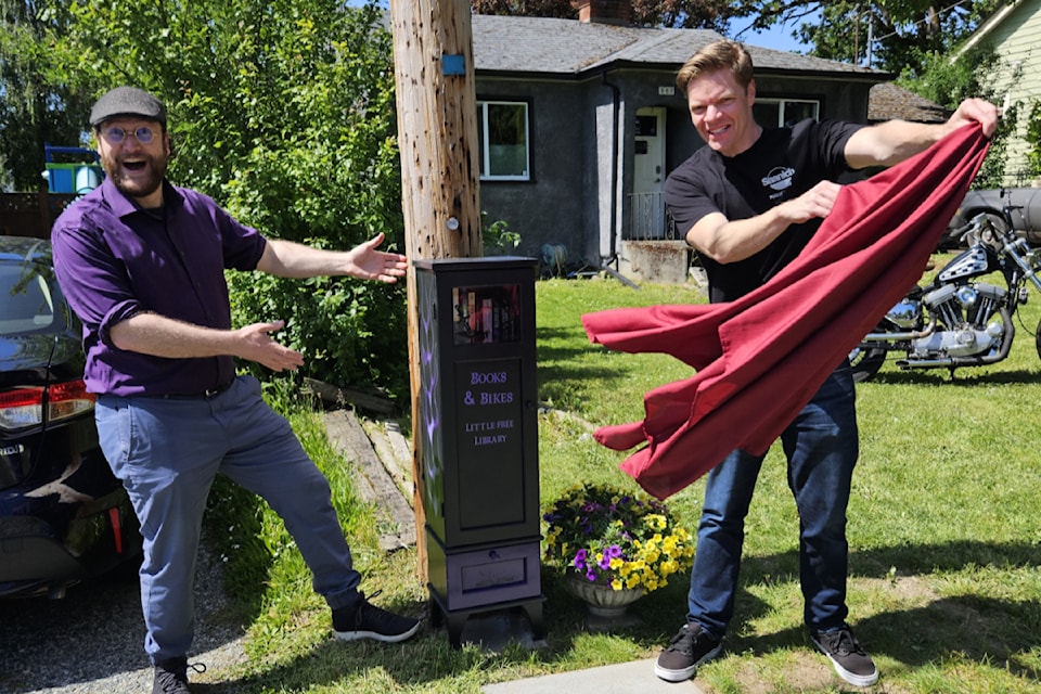 Saanich Mayor Dean Murdock, right, and Coun. Teale Phelps Bondaroff, reveal the 900th little free library mapped by the Greater Victoria Placemaking Network on May 24.