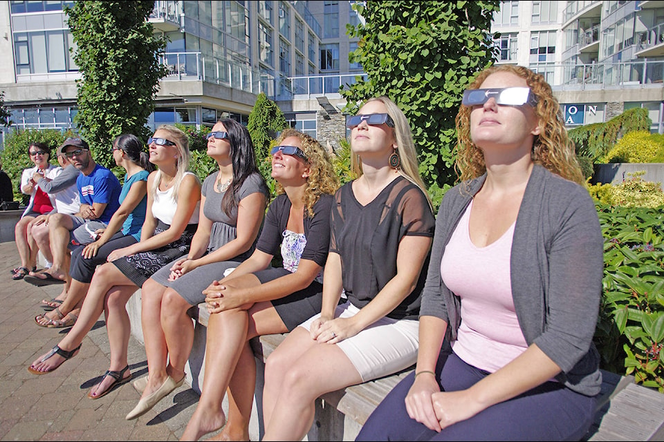 Hundreds of people donned special glasses, used makeshift viewers from cereal boxes or came up with other novel ways of viewing Monday’s partial solar eclipse in Sidney. (Steven Heywood/News staff)