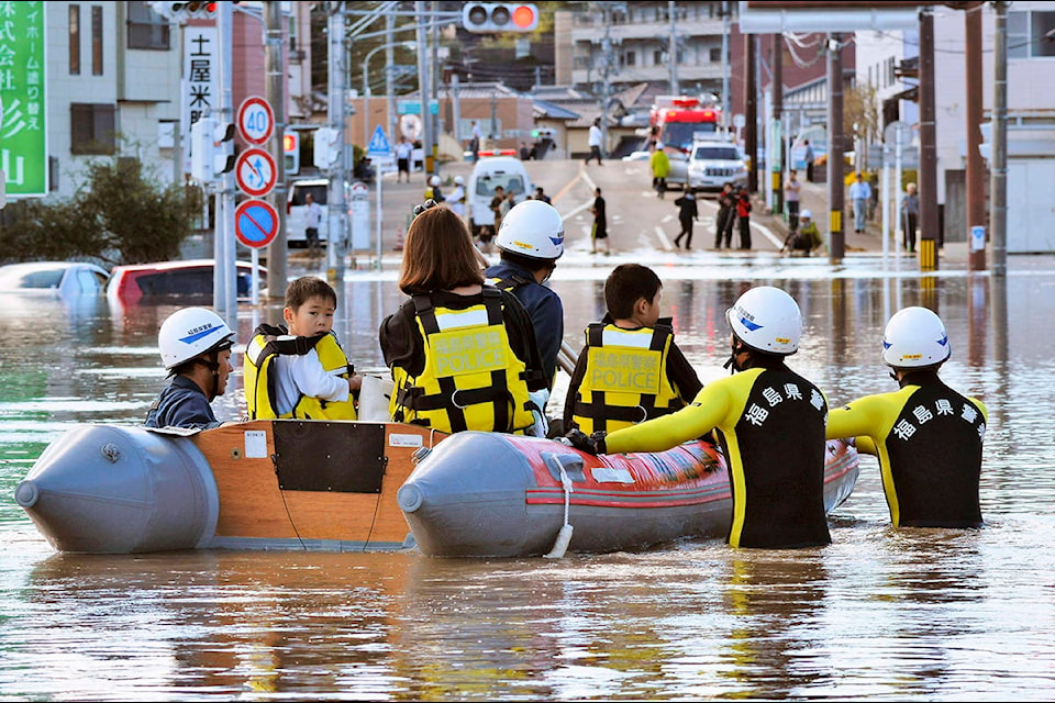 Residents on a rubber boat are rescued as they were stranded by Typhoon Hagibis, in Iwaki, Fukushima prefecture, northern Japan, Sunday, Oct. 13, 2019. Rescue efforts for people stranded in flooded areas are in full force after a powerful typhoon dashed heavy rainfall and winds through a widespread area of Japan, including Tokyo.(Kyodo News via AP)