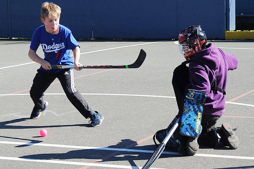 Victoria Admirals peewee hockey player Brady Capson watches the ball bounce off goalie Bennet Harris, March 14 in Parksville. (Michael Briones photo)