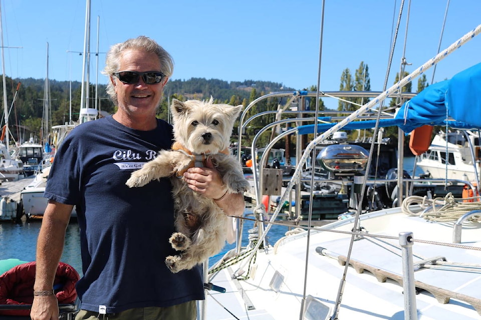 Greg Kyle, who lives at Metchosin’s Pedder Bay RV campgrounds, spent Sunday afternoon cleaning out his boat with 16-year-old dog, Archie. (Aaron Guillen/News Staff)
