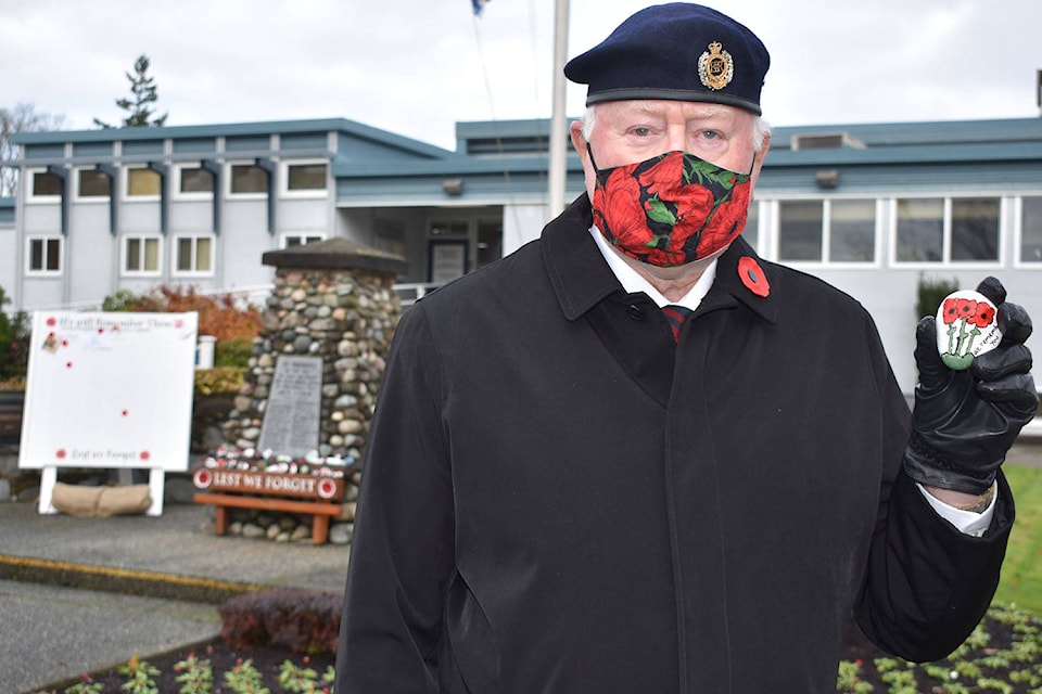 Kenny Podmore of Royal Canadian Legion Saanich Peninsula Branch 37 holds up one of the 40-plus rocks painted with poppies left at Sidney’s cenotaph. (Wolf Depner/News Staff)