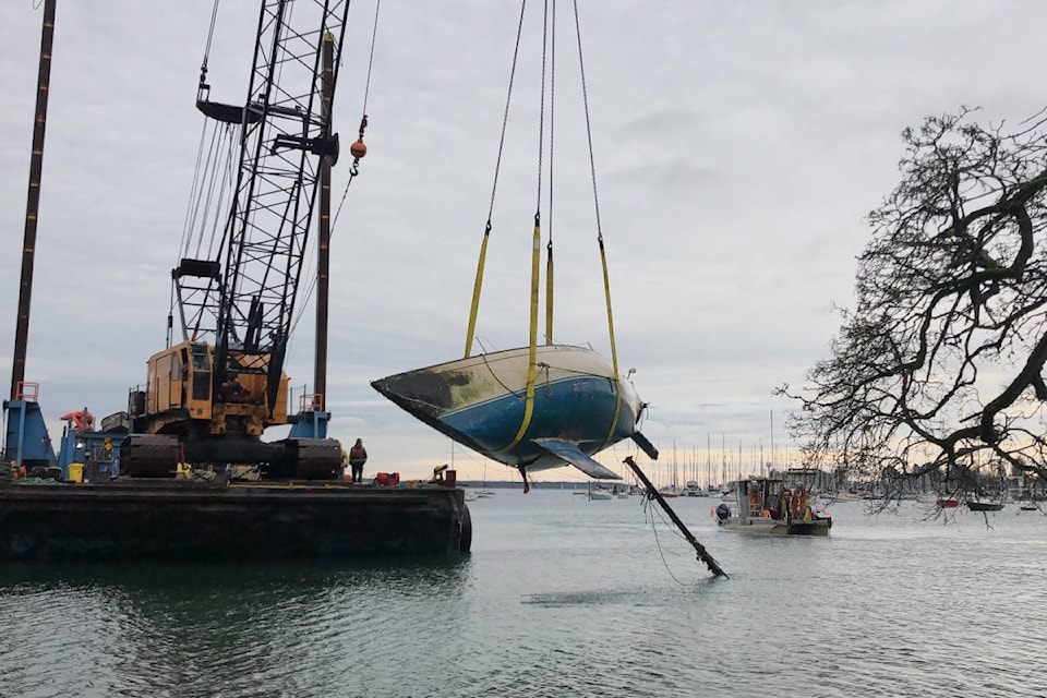 A Salish Sea Industrial crane operator removes a derelict sailboat off the shores of Cadboro Bay on Monday, Dec. 7, 2020. (Travis Paterson/News Staff)
