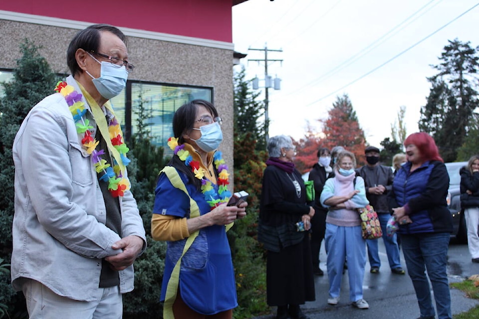 Owners Garvin, left, and Shanon Tse outside Helmcken Market on Oct. 15, its last day in business after 48 years. Community members gathered outside the View Royal market to show their appreciation. (Jake Romphf/News Staff)