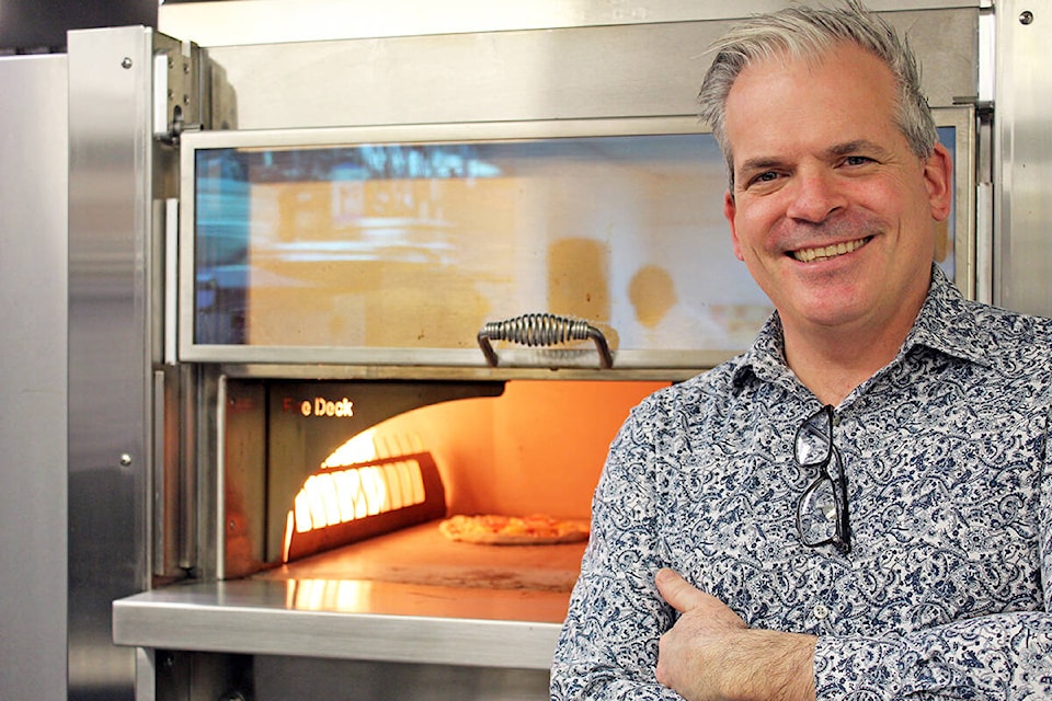 General manager of Stone Ground Pizza, Morgan Watson, shows off their stone-fired pizza oven, a feature of their new location inside the Doubletree Hilton Hotel in downton Victoria. (Megan Atkins-Baker/News Staff)