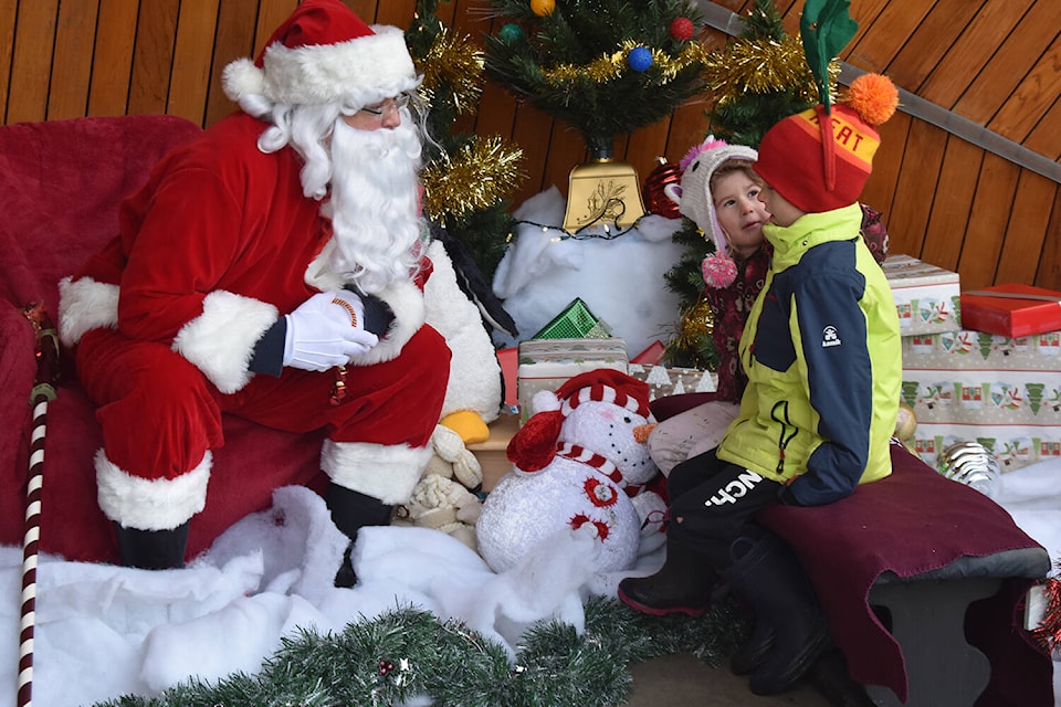 Emma and Will Jantunen are still debating what to ask from Santa during his visit to Sidney as organized by the Peninsula Celebrations Society (Wolf Depner/News Staff)