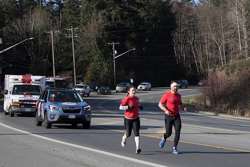 Maria Marciano and Steve Deschamps running along Highway 14, on one of the legs of the Wounded Warrior one-day event, from Sooke to Sidney on Feb. 6. (Bailey Moreton/News Staff)