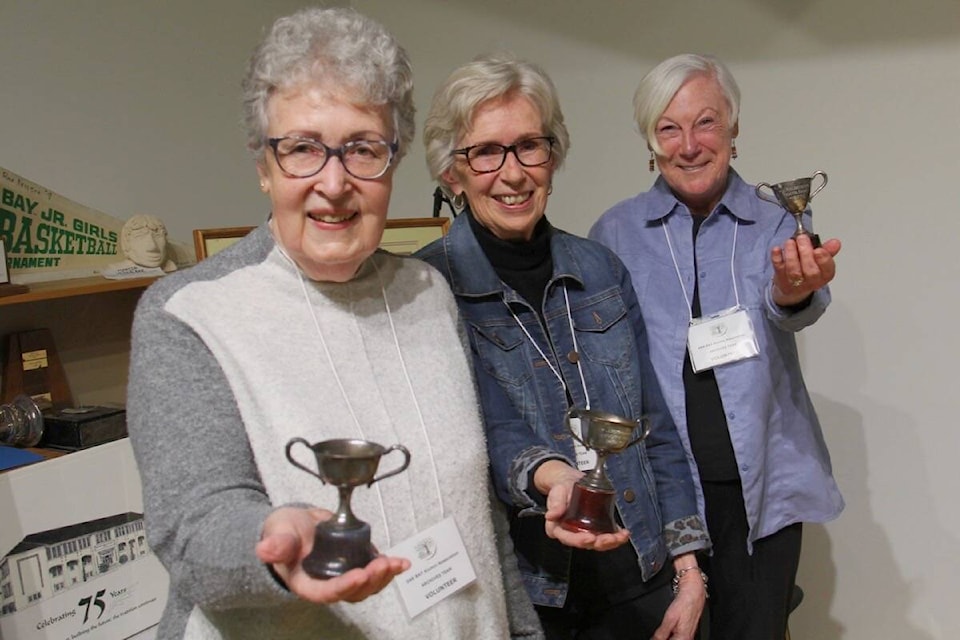Fern Davidson, Jean Sparks and Bronwyn Taylor show a trio of keeper trophies won by James Kinghorn while he attended Oak Bay High. The items and story were donated by Kinghorn’s daughter after his 2014 death. (Christine van Reeuwyk/News Staff)
