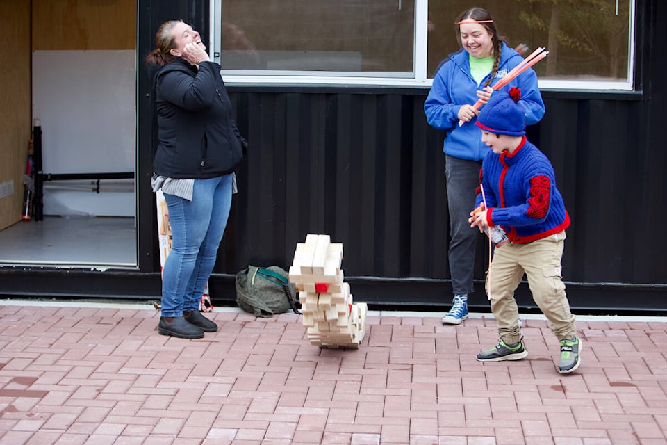 Attendees at the Langford Fall Food Truck Festival react as a giant Jenga tower comes crashing down Saturday. (Justin Samanski-Langille/News Staff)