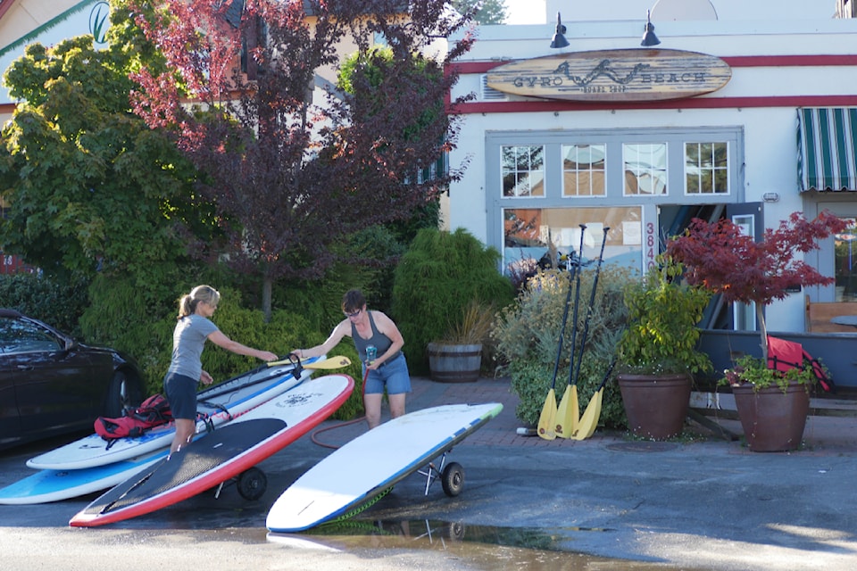 Sam Goski and Catherine Grant set up boards in an area of Cadboro Bay Village destined to become a sidewalk, bike lane and parking. Goskin notes the nearest next bike lane is on Bay Road, a couple kilometres away, adjacent to Oak Bay High.