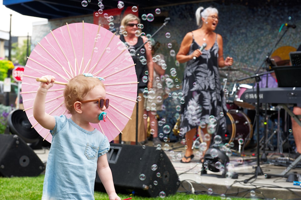 Salem Green enjoys the bubbles blowing by the Ross Street Plaza Stage where The Salmon Armenians perform the first show in the weeklong ROOTSandBLUES Tuned-Up concert series on Monday, July 22, 2024. 