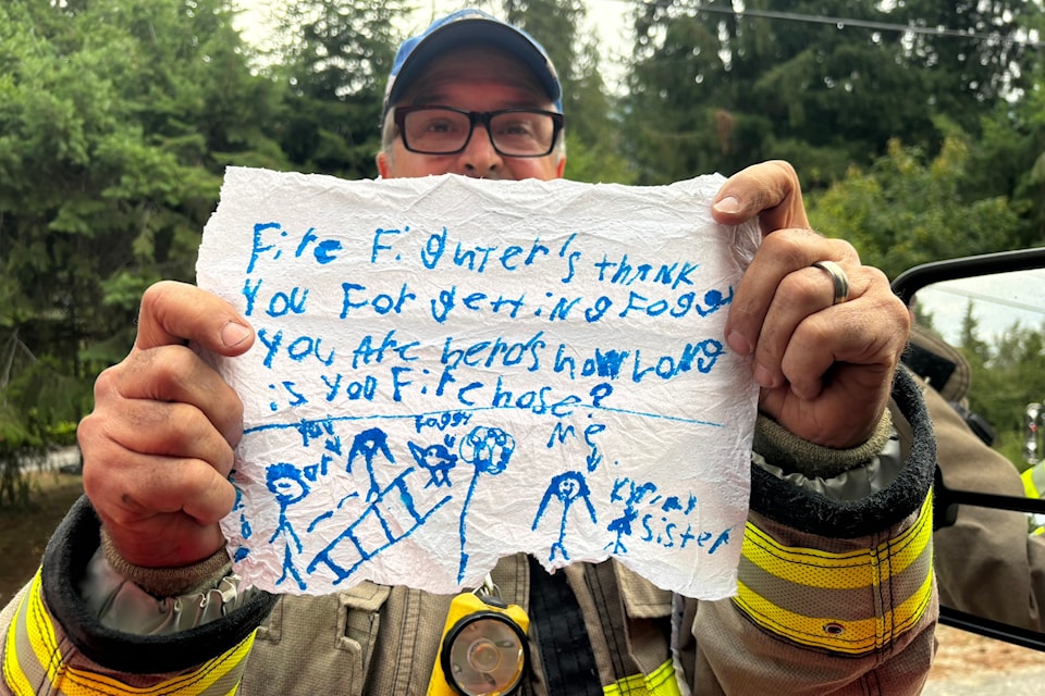 Swansea Point Fire Department deputy chief Don Bakes holds up a heartfelt thank you from Tommi Thomson, 7, who now wants to become a firefighter after the crew rescued her family's cockatiel.