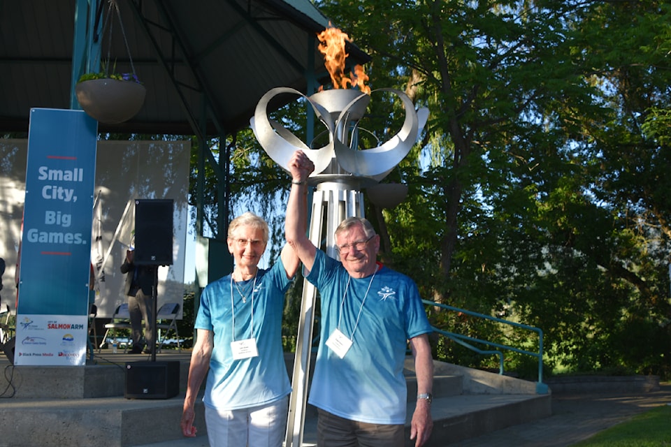 Torch bearers Lois Angle and Ralph Owens raise clasped hands in victory at the kickoff ceremony in Marine Park on Friday, June 7.