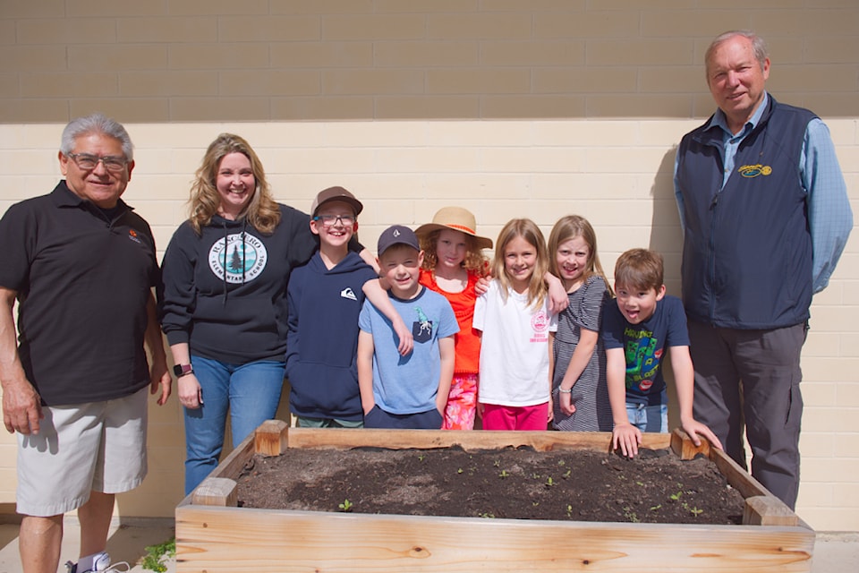 The Shuswap Rotary Club's Caleb Espinoza and Doug Leatherdale (left and right) stand with Ranchero Elementary School teacher Jennifer Leach and students Brett Tarnowski, Parker Reiswig, Rory Faltin, Zoë Hoekstra and Oliver Letham next to a school garden bed planted with budding, bee-friendly pollinator plants grown from seed provided by Rotary. 