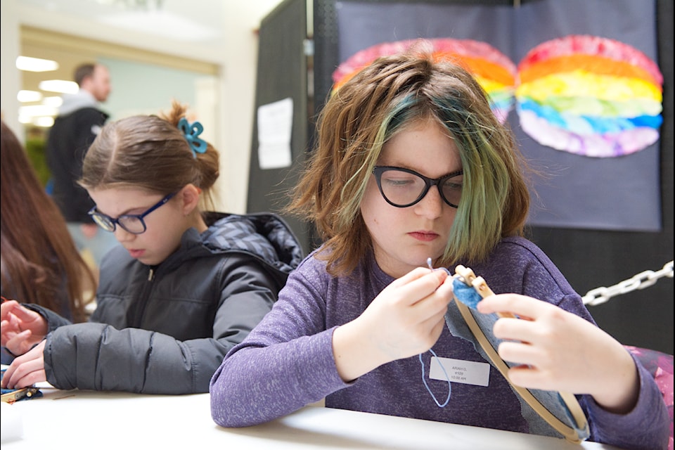 South Broadview Elementary Grade 5 student Ariah Goodman (left) and Grade 4 Parkview student Britton Hutchinson focus on their cross-stitching project in an Elementary District Art Fair workshop led by Judy Surkon at the Mall at Piccadilly on Wednesday, Feb. 12, 2025.