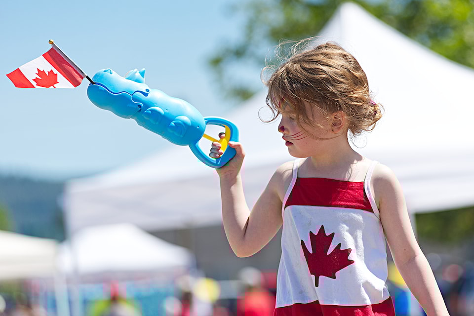Rayna Hall keeps her Canadian flag secured in her toy's mouth during the Canada Day Celebration at Rogers Rink on July 1, 2025. 