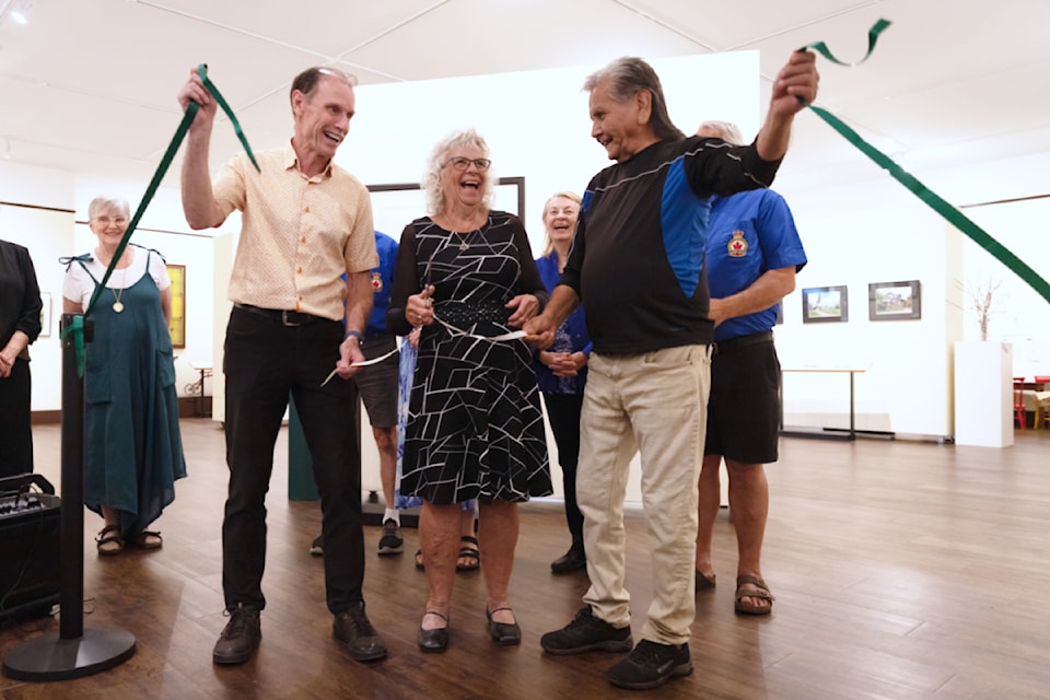 Salmon Arm Mayor Alan Harrison, R.J. Haney president Norma Harisch, and Neskonlith Knowledge Keeper Louis Thomas celebrate after cutting the ribbon at the museum's new exhibit Meet the Register: Re-Painted and Re-acquainted at the opening reception July 9,