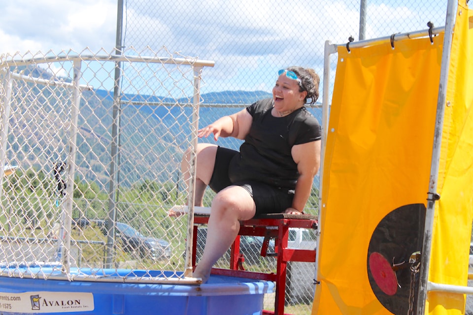 Xanthia Gonzales gamely gets back up on the dunk tank board after a successful shot put her in the water at the Splatsin te Secwépemc Day cultural celebration at the Quilakwa Ball Park in Enderby on June 19. (Heather Black-Salmon Arm Observer)