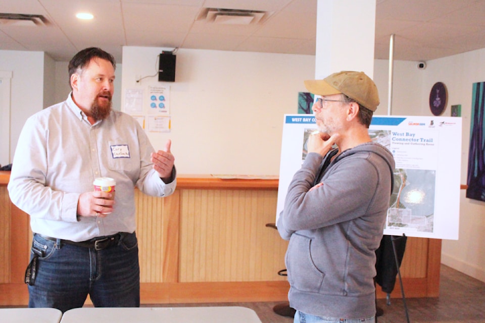 Salmon Arm capital works supervisor Cory Day, left, discusses the proposed West Bay Connector Trail project with Trevor Poole during an open house held at Song Sparrow Hall on Saturday, March 8.