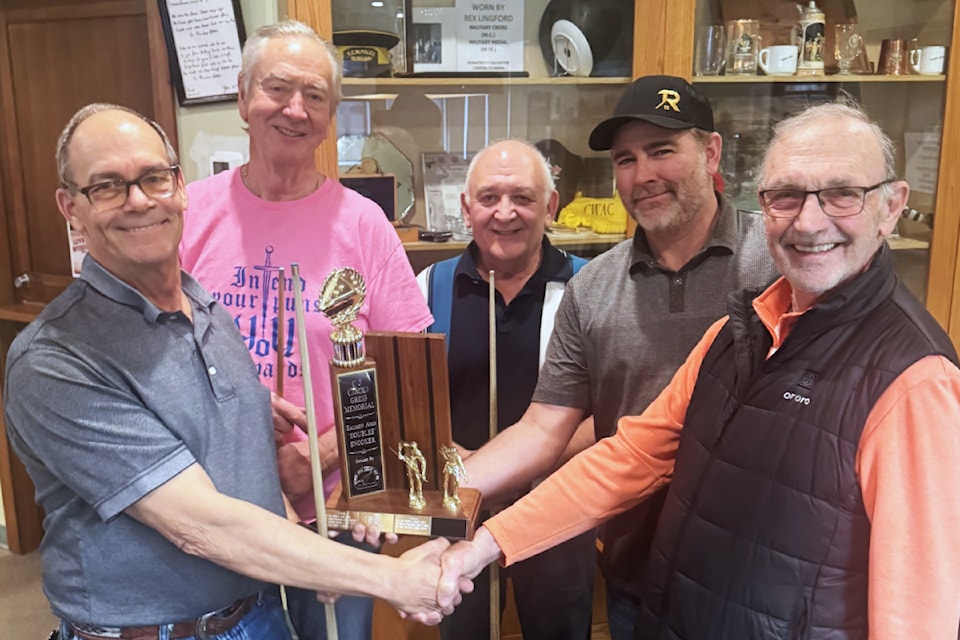 Salmon Arm Legion Friendship Snooker Tournament chair Clarence Wiseman, right, presents the winning trophy to Duster Brown, left, and Brad Crowell for their A Division win, with runner-up winners Dan McKerracher and Jim Barna in behind.