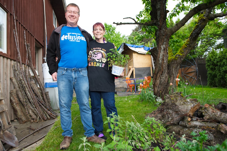 Ivan and Phaedra Idzan stand in their yard where catnip, a legacy of their former cat, Thunder, continues to grow. 