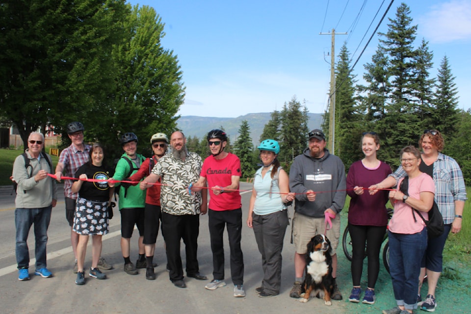 Mayor Alan Harrison, centre, cut the ribbon on the new multi-use path on 16 Street NE with council, staff and public at a ceremony Saturday morning, May 24.