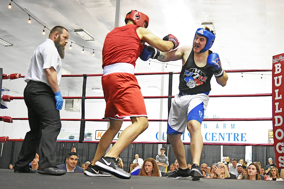 Jim Elliot (blue) of the Salmon Arm Bulldogs (and the Salmon Arm Observer/Eagle Valley News) lands a punch against Thomas Dodman of Kamloops’ Lions Roar Boxing Club. (Lachlan Labere/Salmon Arm Observer)