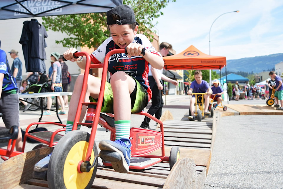 Issac Riep of Canmore, Alta. finds the wood track more difficult than it looks as he rides one of the bikes from the Shuswap Children’s Association’s toy library around around it during the Salty Street Fest event in downtown Salmon Arm on Saturday, May 11. (Lachlan Labere/Salmon Arm Observer)