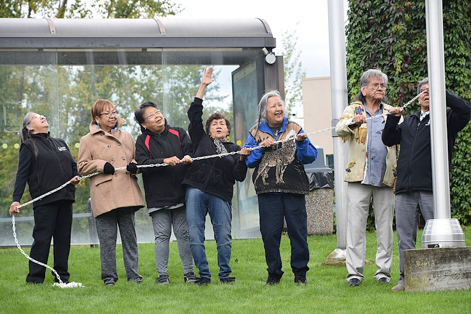 18648137_web1_copy_190927-SAA-flag-raising-elder-women